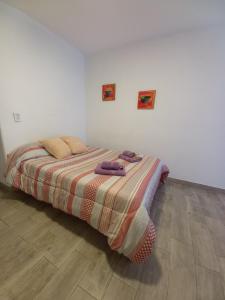 1 dormitorio con 1 cama con manta a rayas en Al mar! en Mar del Plata