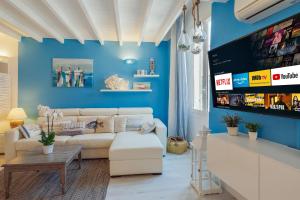 ein Wohnzimmer mit einem weißen Sofa und einer blauen Wand in der Unterkunft Sanremo Amazing Apartment with Private Parking in Sanremo
