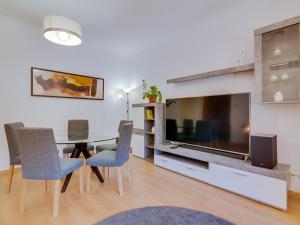 een eetkamer met een tafel en een grote televisie bij AL - Apartamento Vila Sol AG in Vilamoura