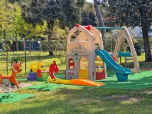 een speeltuin met een glijbaan en playset in een park bij Hotel Villa Elsa in Marina di Massa