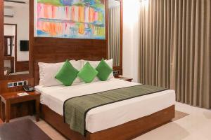 a bedroom with a large bed with green pillows at Hotel SunSet 