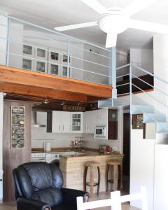 a kitchen with white cabinets and a black leather chair at El Rincón de Doina in Alquézar