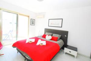 um quarto com uma cama vermelha com duas velas em Le Regency YourHostHelper 4* em Antibes