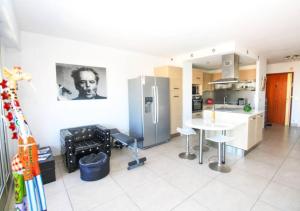 uma cozinha com um frigorífico, uma mesa e cadeiras em Le Regency YourHostHelper 4* em Antibes