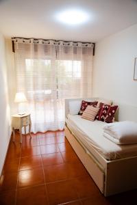 a small bedroom with a bed and a window at Apartamentos Costa Norte in San Vicente de la Barquera