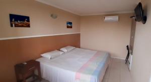 - une chambre avec un grand lit blanc dans l'établissement Ecopousada Miriti, à Belém