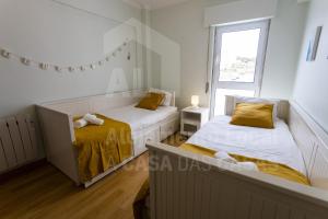 two beds in a small room with a window at Home Sweet Home by ACasaDasCasas in Ericeira