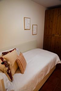 a bedroom with a bed with white sheets and pillows at Apartamentos Costa Norte in San Vicente de la Barquera