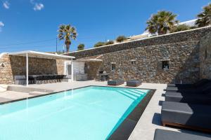 a villa with a swimming pool and a stone wall at Villa Cataleya 1 PRIVATE POOL in Fanari