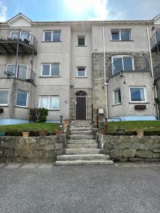 a building with stairs leading up to a door at Eton Court Apartments in Newquay