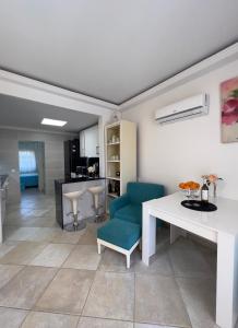 a living room with a white table and a blue chair at Espectacular Bajo Lirio in Calpe