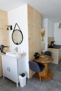 a bathroom with a sink and a table and chairs at Le Cocon de Lily in Saint-Savin-de-Blay