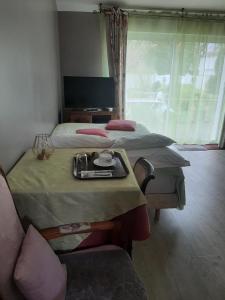 een slaapkamer met 2 bedden en een tafel en een stoel bij chambre d hotes in Saint-Laurent-de-la-Barrière