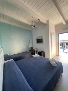 a bedroom with a large blue bed with two pillows at La Tonnara B&B in Palmi