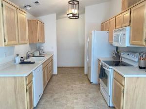 a kitchen with white appliances and wooden cabinets at Hot Tub! King Bed-firepitt-near Airport& Freeway in Medford