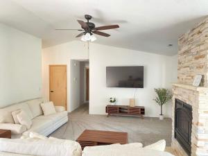 a living room with a ceiling fan and a fireplace at Hot Tub! King Bed-firepitt-near Airport& Freeway in Medford