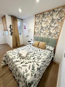 a bedroom with a large bed with a floral bedspread at Casa Secunda Romar in Córdoba