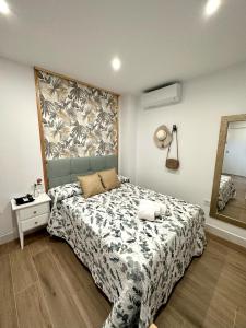 Dormitorio con cama con manta estampada de flores en Casa Secunda Romar, en Córdoba