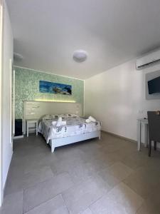 - une chambre avec un lit et une peinture murale dans l'établissement La Tonnara B&B, à Palmi
