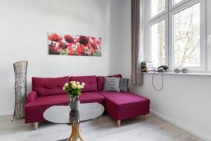 ソポトにあるKierunek Sopot Apartament DELUXE II Królowej Jadwigi 7の紫色のソファとテーブル付きのリビングルーム