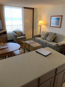 - un salon avec un canapé et une table dans l'établissement Barclay Towers, à Virginia Beach