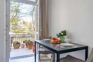 a dining room table with a bowl of fruit on it at Kierunek Sopot Apartament DELUXE II Królowej Jadwigi 7 in Sopot