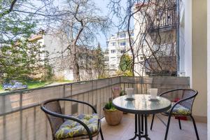 a table and chairs on a balcony with a window at Kierunek Sopot Apartament DELUXE II Królowej Jadwigi 7 in Sopot