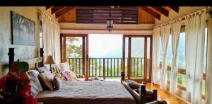 a bedroom with a bed and a large window at Montañas VIP Family Room in Constanza