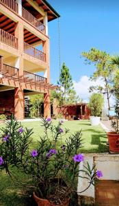 a building with purple flowers in front of a yard at Montañas VIP Family Room in Constanza