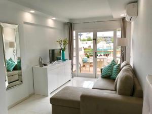 a living room with a couch and a television at Costa Adeje Modern Studio, close to the beach in Adeje