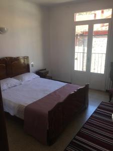 Un dormitorio con una cama grande y una ventana en Maison les Ramparts, en Villefranche-de-Conflent