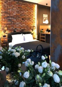 a bedroom with a bed and a bouquet of white roses at Loft House Premium Apartments in Wrocław