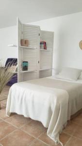 Un dormitorio con una cama con una manta blanca. en Maison Planier, havre de paix proche mer et centre, en Sausset-les-Pins