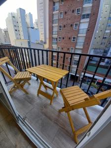 a wooden table and two chairs on a balcony at Al mar! in Mar del Plata