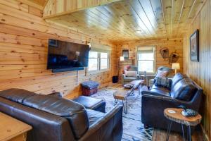 a living room with leather furniture and a flat screen tv at Riverfront Rumney Vacation Rental with Fire Pit! in Rumney