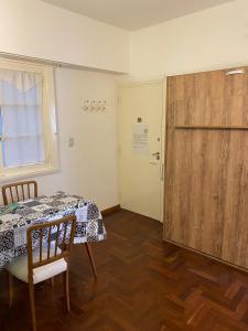 Habitación con mesa y puerta de madera. en Departamento Mar del Plata en Mar del Plata