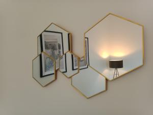 un grupo de espejos en una pared con una lámpara en Le petit cocon de la poste, en Gourdon-en-quercy