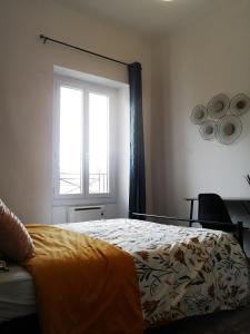 1 dormitorio con cama y ventana en Le petit cocon de la poste, en Gourdon-en-quercy