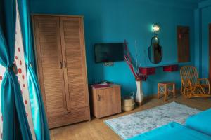 ein Wohnzimmer mit einem TV und einer blauen Wand in der Unterkunft Hotel Pamela Concept in Negotino