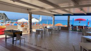 a restaurant with tables and chairs and the beach at La Tonnara B&B in Palmi
