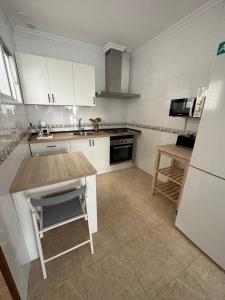 uma cozinha com armários brancos e uma bancada em Apartamento Entre dos mares em Tarifa