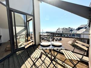 d'une table à manger sur un balcon avec vue sur la rue. dans l'établissement T2 neuf Top Cocooning – Terrasse – Face à la mer, à Ploemeur