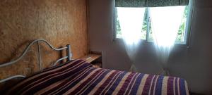 1 dormitorio con 1 cama con manta a rayas y ventana en Jeluma1 en Vaqueros