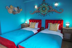 two beds in a room with blue walls at Hotel Pamela Concept in Negotino