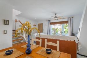 un comedor con una mesa con un jarrón. en Casa en la playa con piscinas E, en Puerto Marino