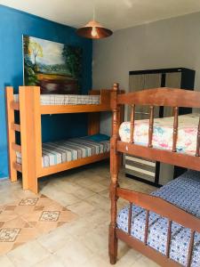a room with two bunk beds and a painting at Apart Fraga Maia in Feira de Santana