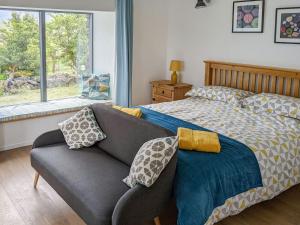 a bedroom with a couch and a bed and a window at The Beach House in Dunvegan