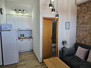 a living room with a couch and a kitchen at Apartments San in Sukošan