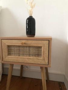 a black vase sitting on top of a wooden table at Chez julie in Caen