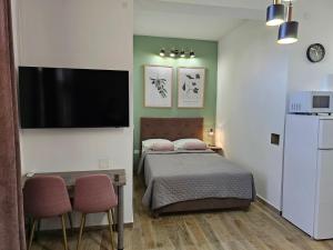 Schlafzimmer mit einem Bett und einem Flachbild-TV in der Unterkunft Apartments San in Sukošan